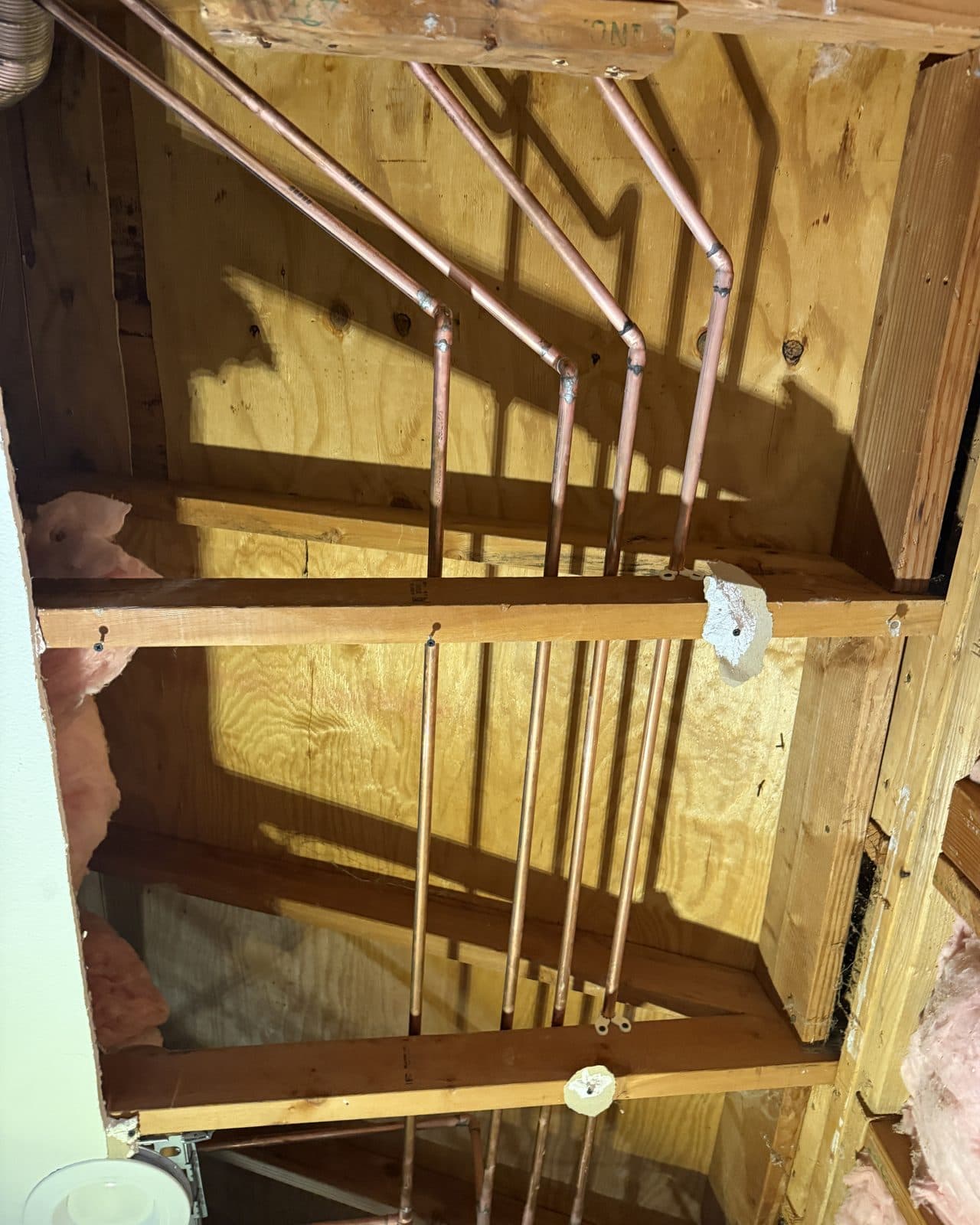 Copper supply lines running through open wall and ceiling framing