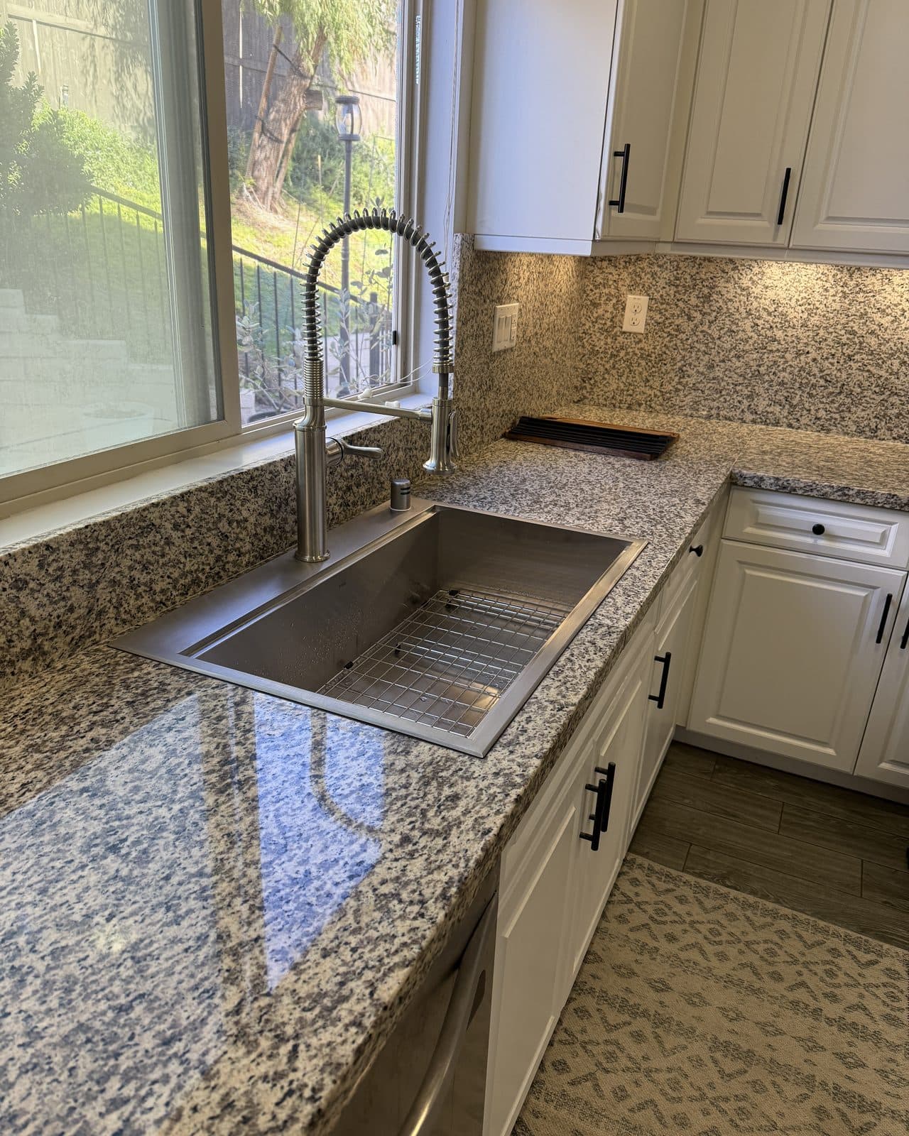 Stainless kitchen sink and pull down faucet set in a granite counter