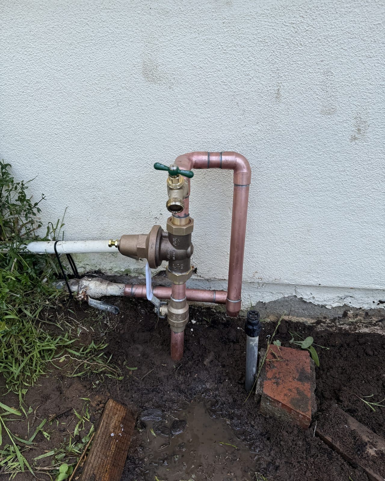 Pressure regulator and hose bibb on a copper line at an exterior wall